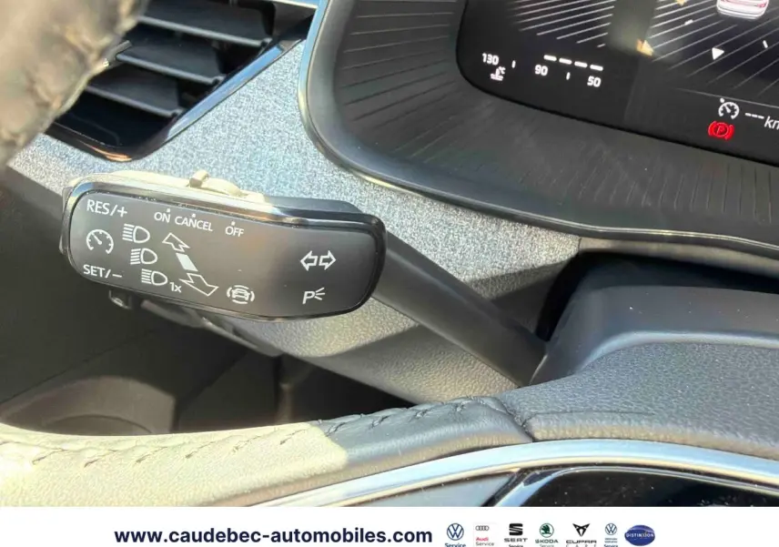 Gros plan sur la commande de régulateur de vitesse et le tableau de bord numérique du Skoda Kamiq blanc 2025.