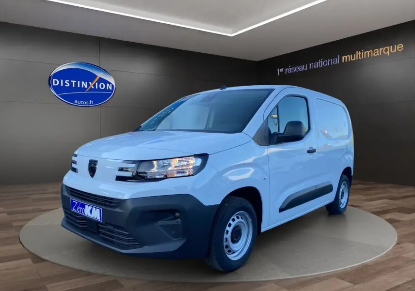 Peugeot Partner blanc vue 3/4 avant droit, fourgonnette utilitaire avec pare-chocs noirs et jantes acier simples.