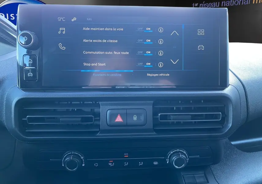 Écran tactile central du tableau de bord du Peugeot Partner blanc 2024 affichant les aides à la conduite.