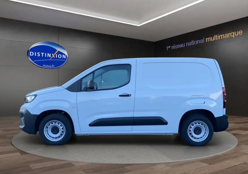Peugeot Partner blanc en vue latérale droite, avec protections noires sur les portes et jantes acier simples.
