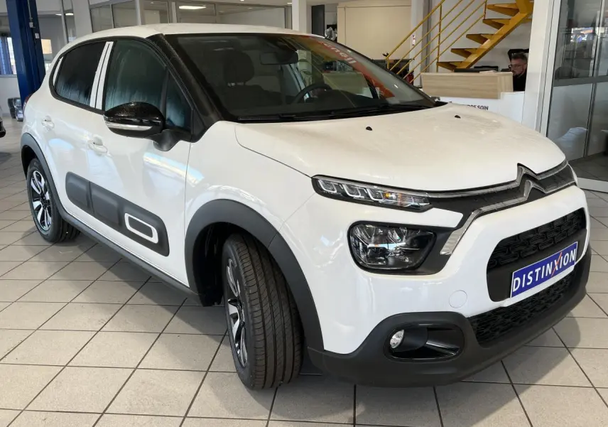 Citroën C3 blanc banquise vue 3/4 avant droit avec Airbump noir et coques de rétroviseurs noires dans un showroom.
