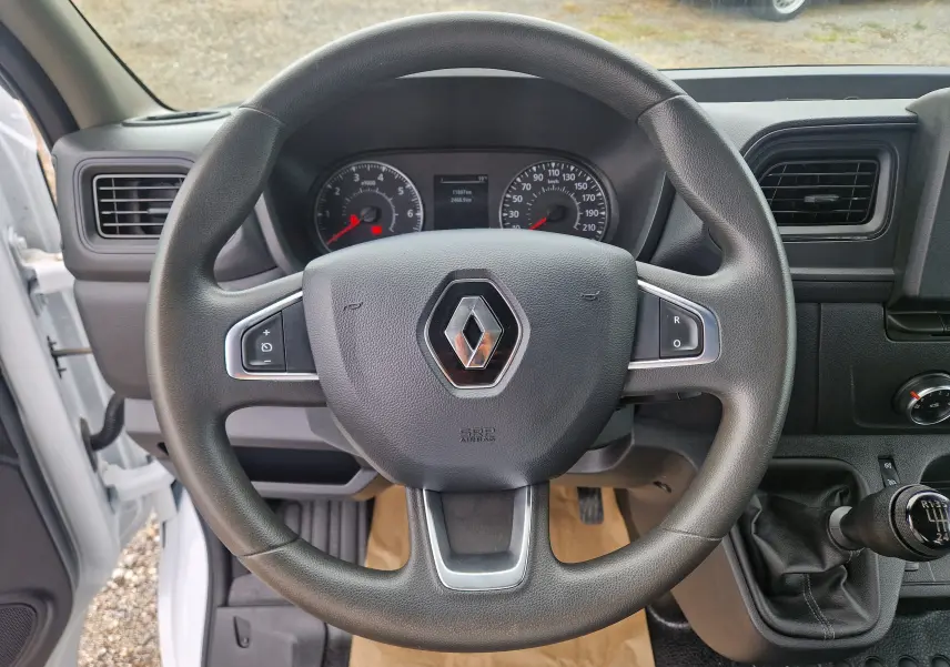 Vue rapprochée du volant noir du Renault Master Châssis Cabine 2024 avec tableau de bord et levier de vitesses manuel.