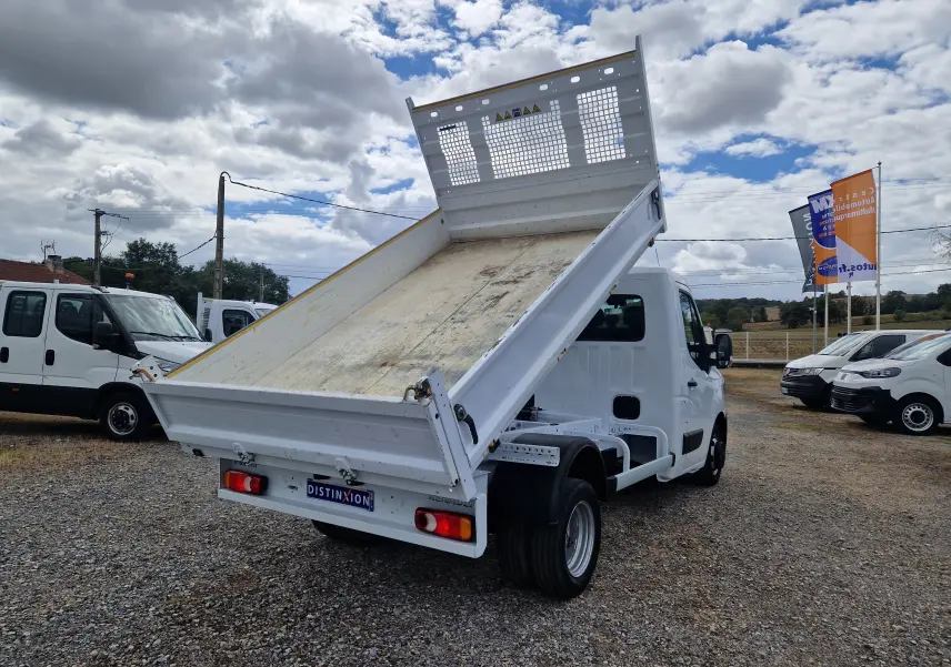 Renault Master Châssis cabine blanc vu 3/4 arrière avec benne basculante relevée et roues jumelées.