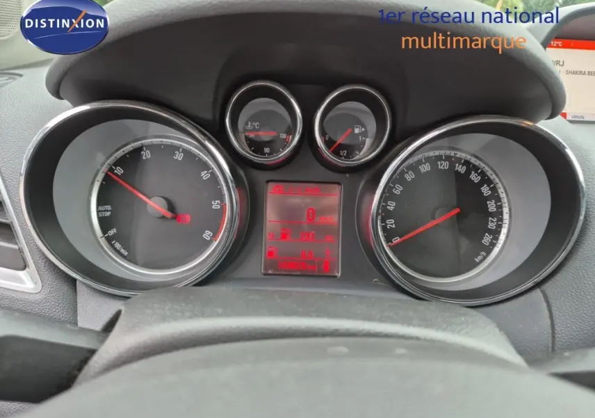 Vue rapprochée du tableau de bord et compteurs d’un Opel Mokka bleu outremer, affichage digital rouge au centre.