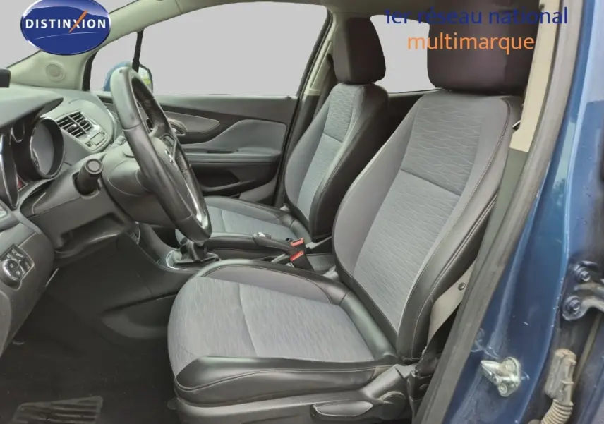 Vue intérieure côté conducteur de l'Opel Mokka bleu outremer, montrant les sièges avant et le volant multifonction cuir.