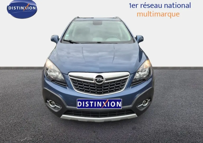Vue avant d'un Opel Mokka bleu outremer avec calandre chromée et phares allumés sur fond neutre.
