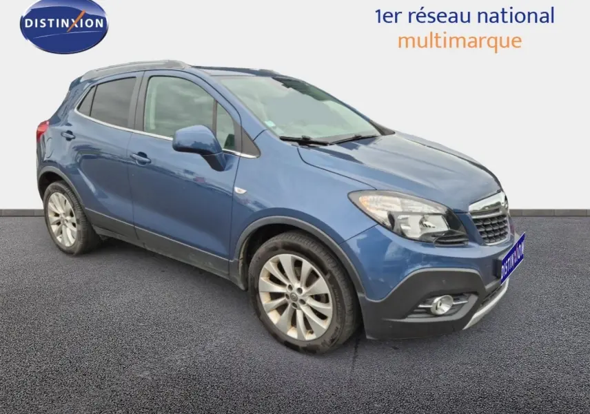 Opel Mokka bleu outremer en 3/4 avant droit, avec jantes alu et barres de toit visibles.