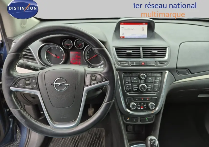 Vue intérieure centrée sur le volant cuir Opel Mokka bleu outremer avec tableau de bord et console centrale détaillée.