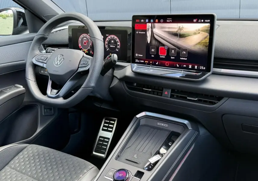 Vue intérieure côté conducteur du Volkswagen T-Roc 2026, volant cuir multifonction et grand écran tactile central allumé.