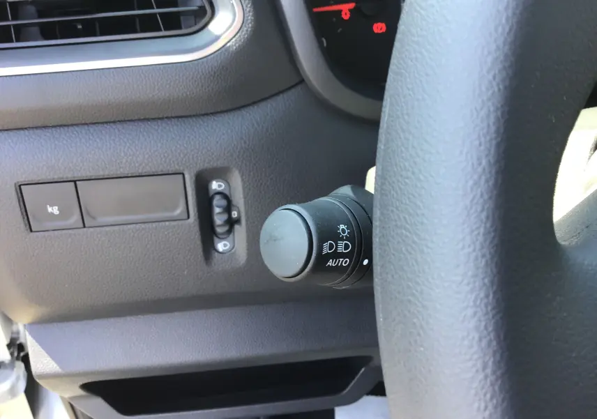 Détail du commodo d'éclairage à gauche du volant dans l'habitacle du Renault Master gris étoile 2024.