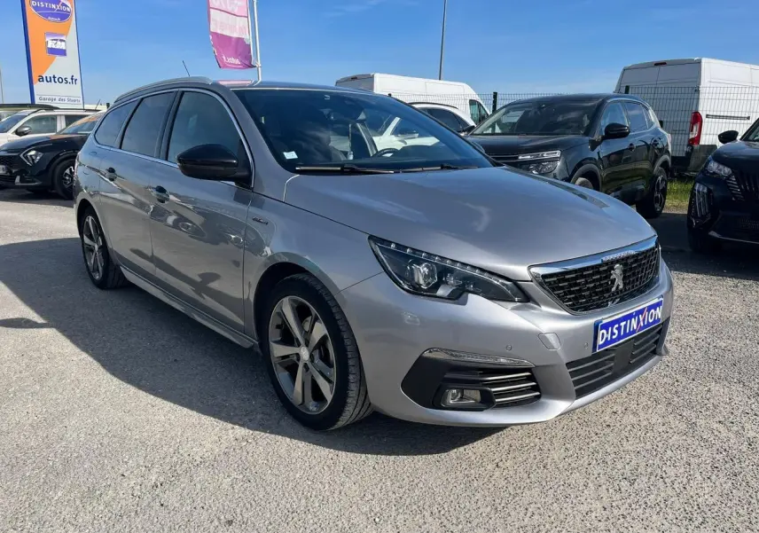 Peugeot 308 SW gris clair vue 3/4 avant droit avec jantes alliage et calandre noire au soleil