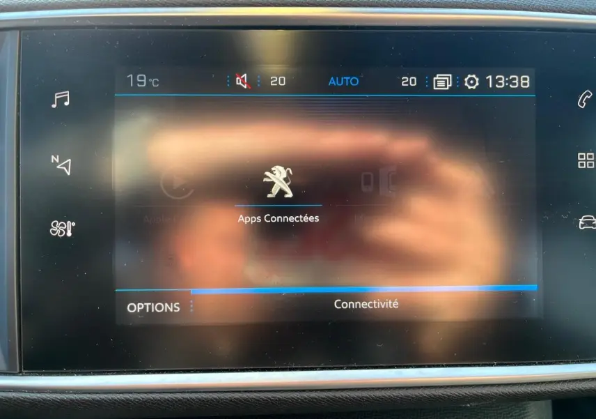 Écran tactile 9,7 pouces du Peugeot 308 SW GT Line 2019 affichant les apps connectées, avec reflet de mains.