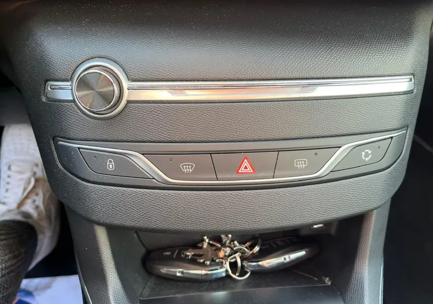 Gros plan sur la console centrale noire de la Peugeot 308 SW GT Line avec clés posées en bas.