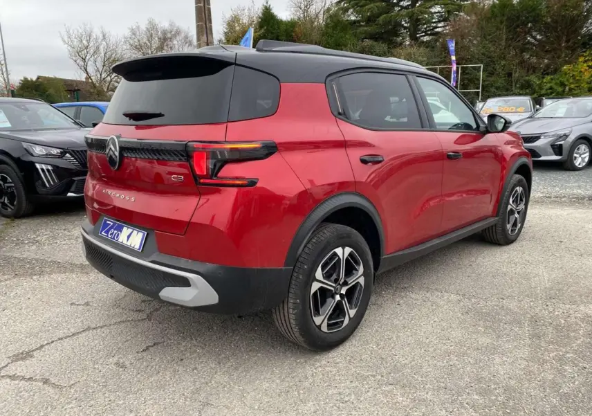 Vue 3/4 arrière droite d'un Citroën C3 Aircross rouge Elixir avec toit noir et jantes alliage 17 pouces.