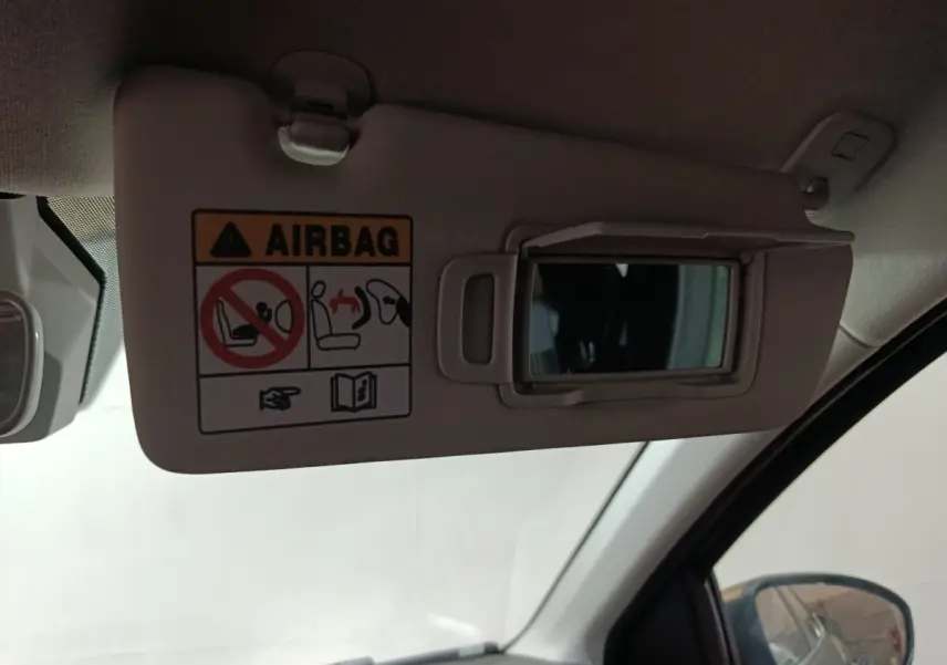 Détail du pare-soleil côté conducteur avec miroir et avertissement airbag dans une Dacia Sandero 2024.