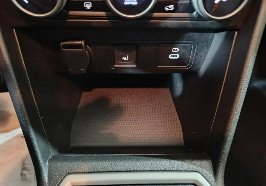 Vue rapprochée de la console centrale noire de la Dacia Sandero Extreme+ TCe 110 avec prises USB et bouton de commande.