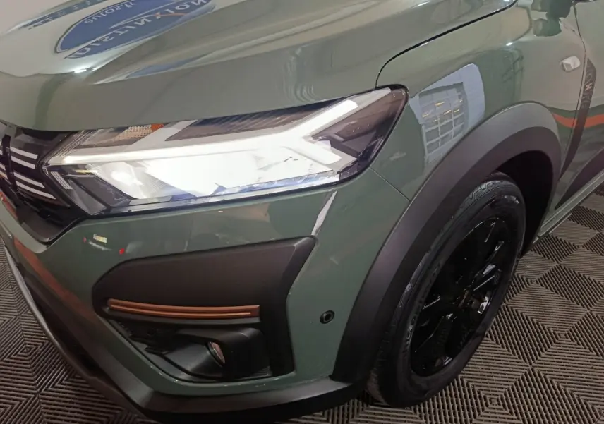Gros plan sur l'avant droit vert d'une Dacia Sandero Extreme+ 2024 avec phares LED et jante noire.