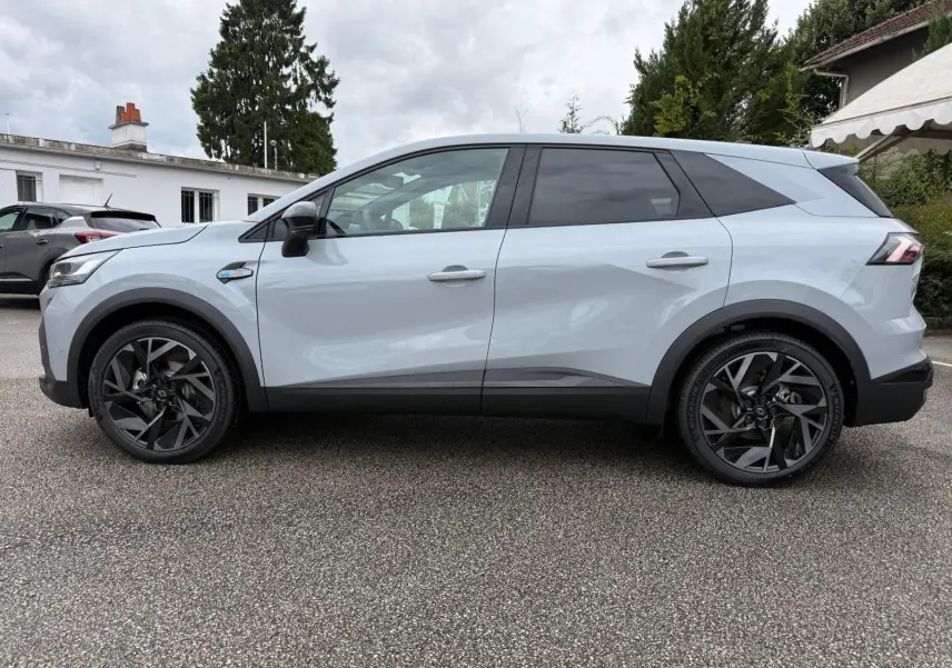 Vue de profil côté gauche du Renault Symbioz gris rafale, soulignant ses jantes noires au design moderne.
