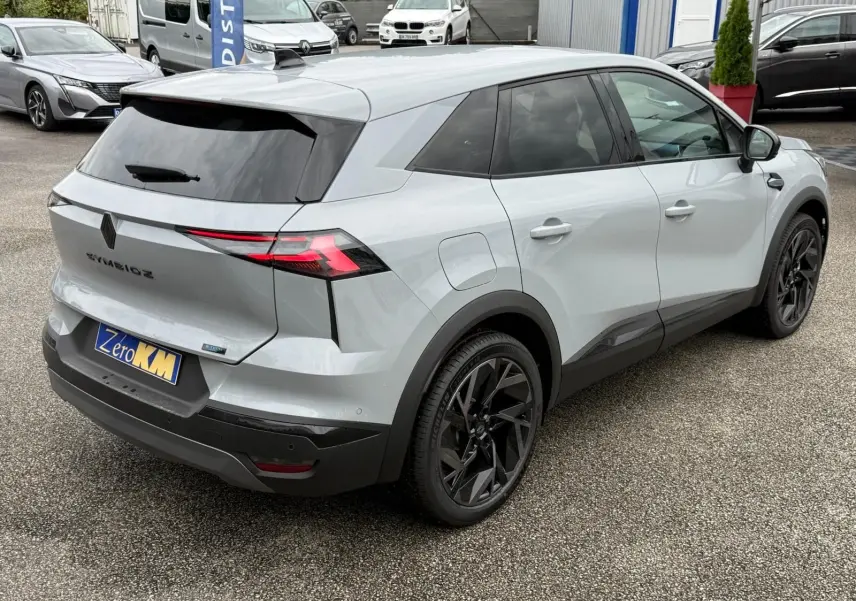 Vue 3/4 arrière droite d'un Renault Symbioz gris Rafale avec jantes noires et feux arrière LED distinctifs.