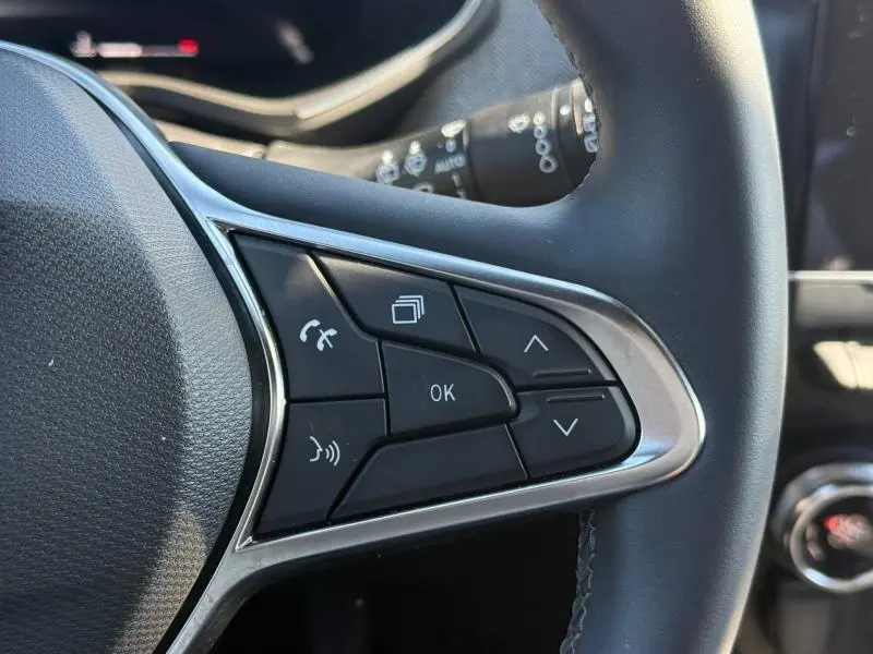 Gros plan sur les commandes multifonctions à droite du volant de la Renault Clio 2025, finition Techno, avec boutons de navigation et appel.