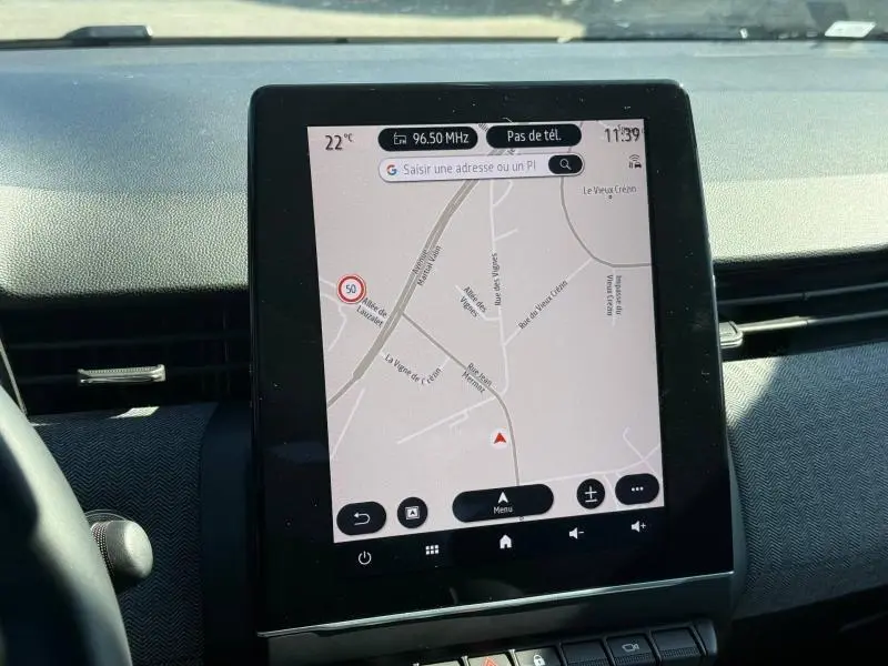 Écran tactile central affichant la navigation dans l’habitacle d’une Renault Clio Bleu Iron, vue de face.