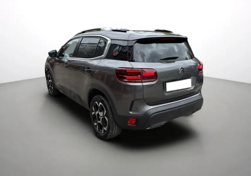 Vue 3/4 arrière droite d'un Citroën C5 Aircross gris platinium avec vitres surteintées et jantes alu 18 pouces.