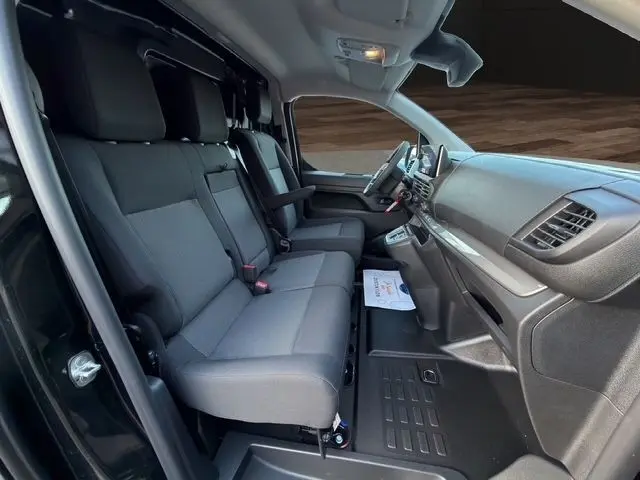 Vue intérieure côté gauche du Citroën Jumpy noir 2026, montrant la banquette avant 3 places et le tableau de bord moderne.