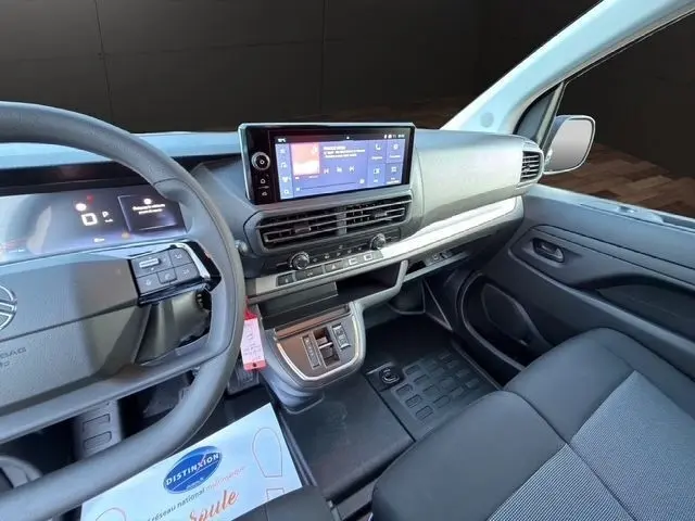 Vue intérieure côté conducteur du tableau de bord noir et gris du Citroën Jumpy 2026 avec écran tactile central et volant multifonctions.