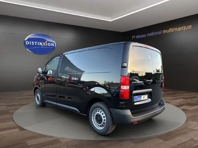 Vue 3/4 arrière droite d’un Citroën Jumpy noir 2026, fourgon fermé avec vitres arrière teintées et jantes acier.