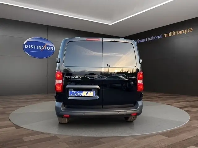 Vue arrière d'un Citroën Jumpy noir 2026, portes battantes fermées, sur plateforme en showroom.