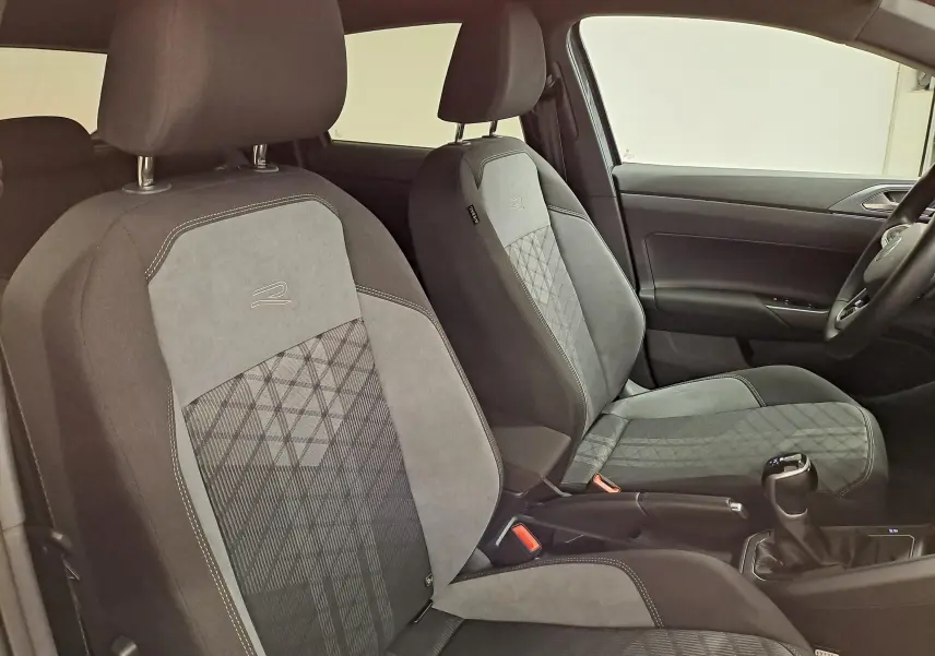 Vue intérieure côté droit des sièges avant gris avec surpiqûres et logo R de la Volkswagen Polo 2025 R-Line Edition.