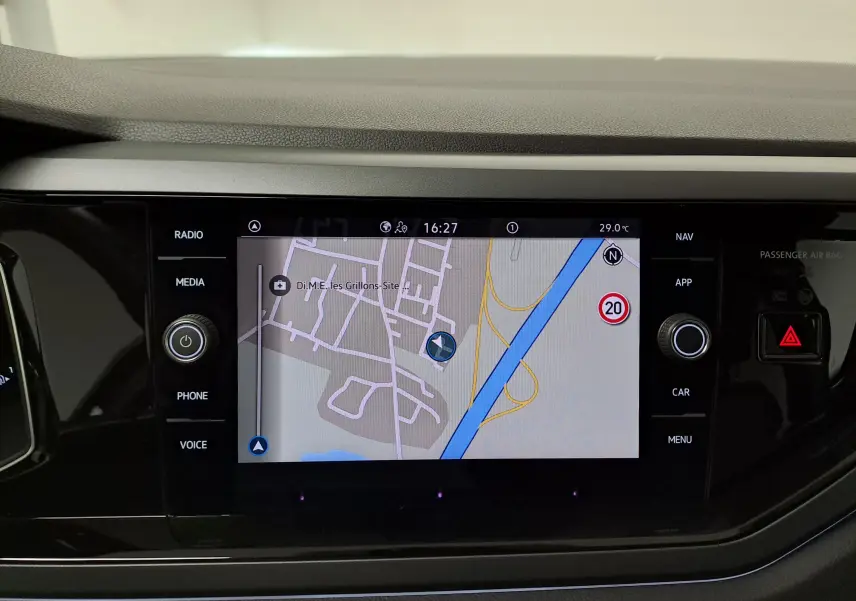Écran tactile central du tableau de bord de la Volkswagen Polo 2025 avec navigation affichée, boutons autour en noir brillant.