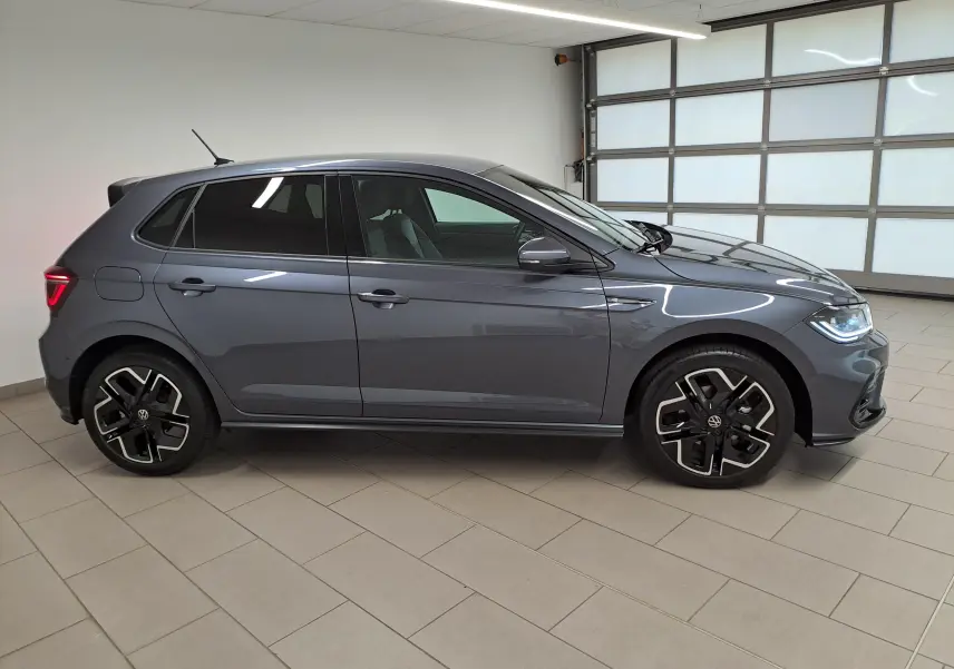Volkswagen Polo 1.0 TSI 116 DSG7 R-Line Edition gris cendré vue de profil côté gauche en intérieur showroom.