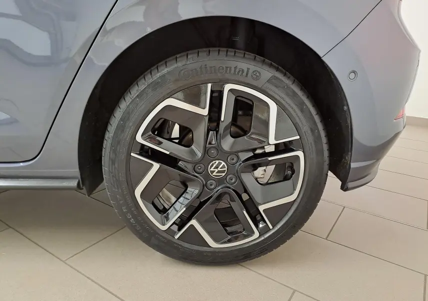 Gros plan sur la roue arrière droite d'une Volkswagen Polo gris cendré avec jante noire et argentée au design R-Line.
