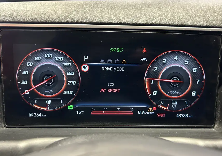 Tableau de bord numérique du Hyundai Tucson Hybrid gris, affichant le mode Sport et la vitesse à zéro km/h.