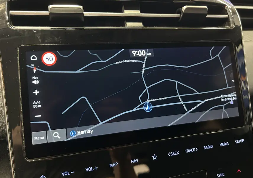 Vue rapprochée de l’écran GPS tactile du Hyundai Tucson gris, affichant une carte de navigation avec indication de vitesse à 50 km/h.