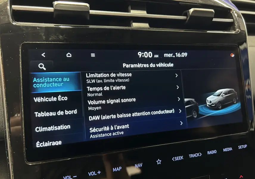 Écran tactile central du Hyundai Tucson Hybrid 2022 affichant les paramètres d’assistance au conducteur en intérieur noir.
