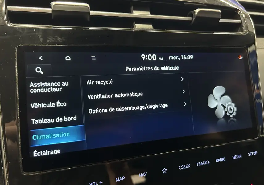 Écran tactile central du Hyundai Tucson gris, affichant les paramètres de climatisation en intérieur, vue rapprochée.