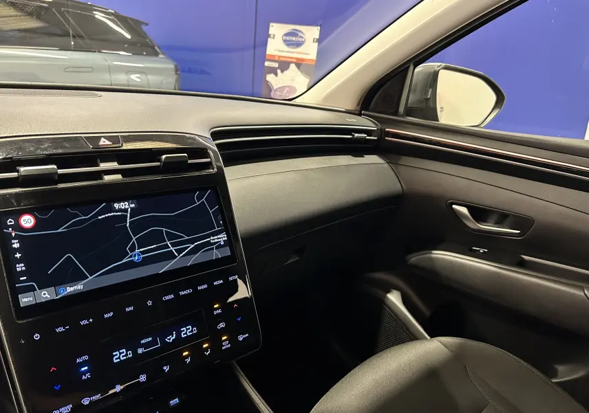 Vue intérieure côté passager du Hyundai Tucson Hybrid 2022, avec écran tactile GPS et finition noire élégante.