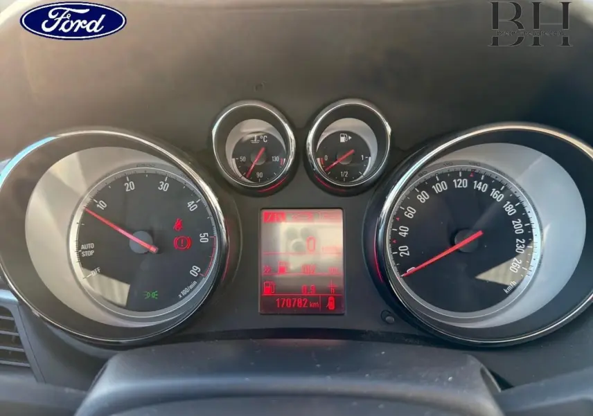 Gros plan sur le tableau de bord d’un Opel Zafira Tourer 2013, affichage numérique rouge et compteurs analogiques.