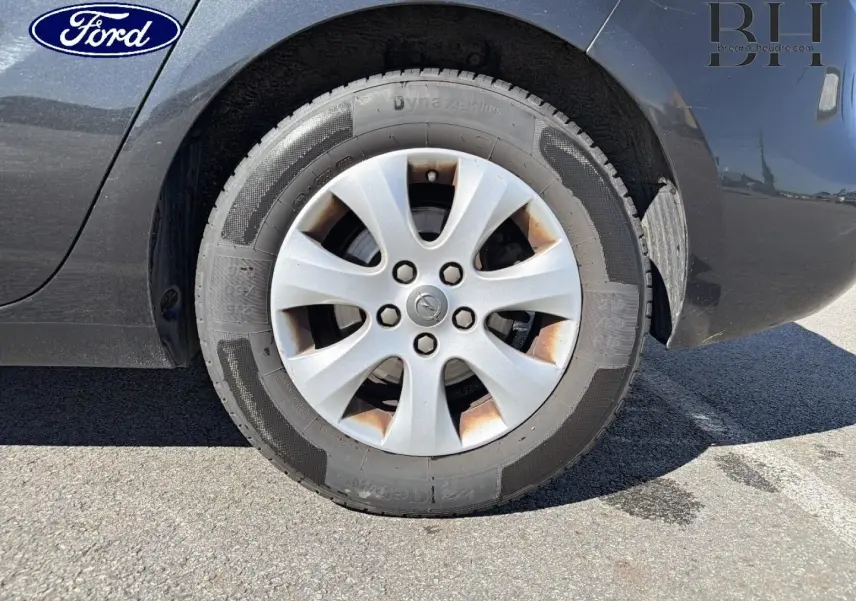 Gros plan sur la roue avant droite grise métallisée d’un Opel Zafira Tourer 2013 avec jante en alliage.