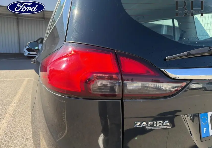 Gros plan sur l'arrière droit gris métal de l'Opel Zafira Tourer avec feu arrière et logo Zafira visible.