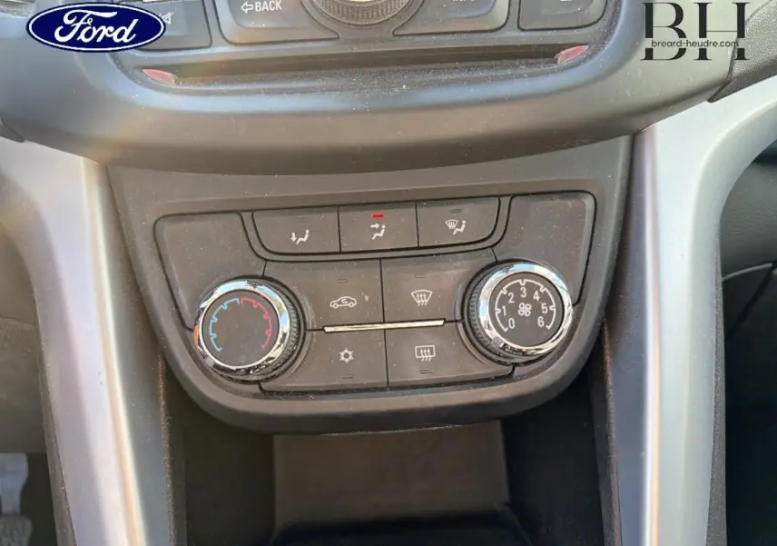 Détail du tableau de bord noir avec commandes de climatisation d'une Opel Zafira Tourer gris métal, vue frontale rapprochée.