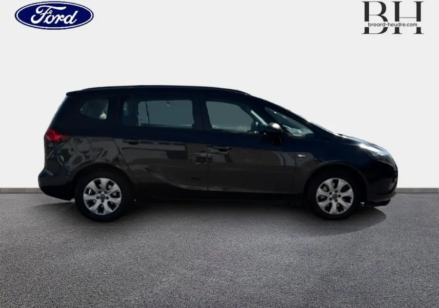 Vue de profil côté gauche d’un Opel Zafira Tourer gris métal, monospace compact avec vitres teintées et jantes alliage.