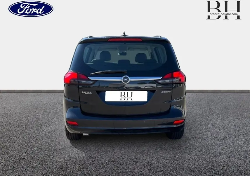 Vue arrière d'un Opel Zafira Tourer gris métal, montrant ses feux rouges et la lunette arrière avec essuie-glace.
