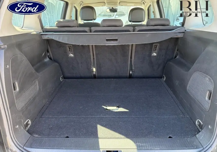 Coffre spacieux vu de l'arrière avec banquette arrière noire et cache-bagages dans un Opel Zafira Tourer gris métal.
