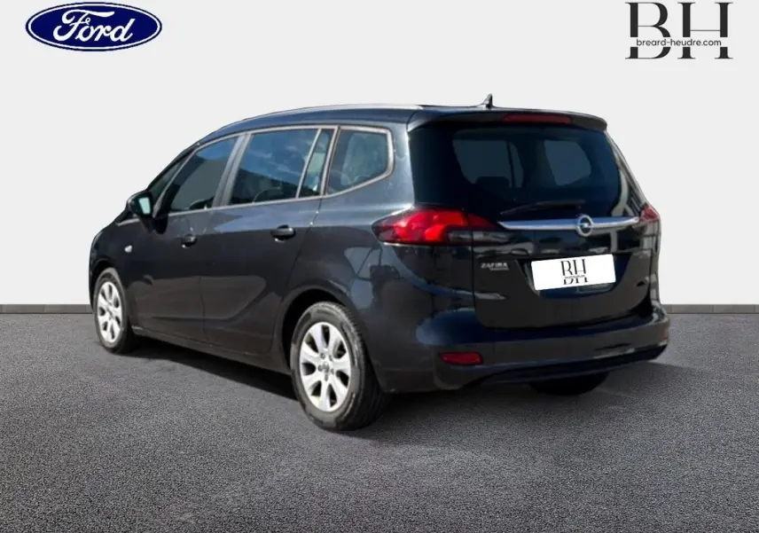 Opel Zafira Tourer gris métal vue 3/4 arrière droit, avec feux arrière rouges et vitres teintées.