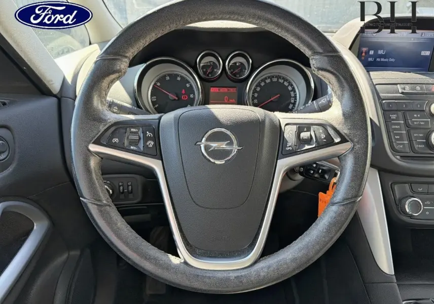 Vue intérieure centrée sur le volant cuir d'une Opel Zafira Tourer 2013 avec tableau de bord et commandes visibles.