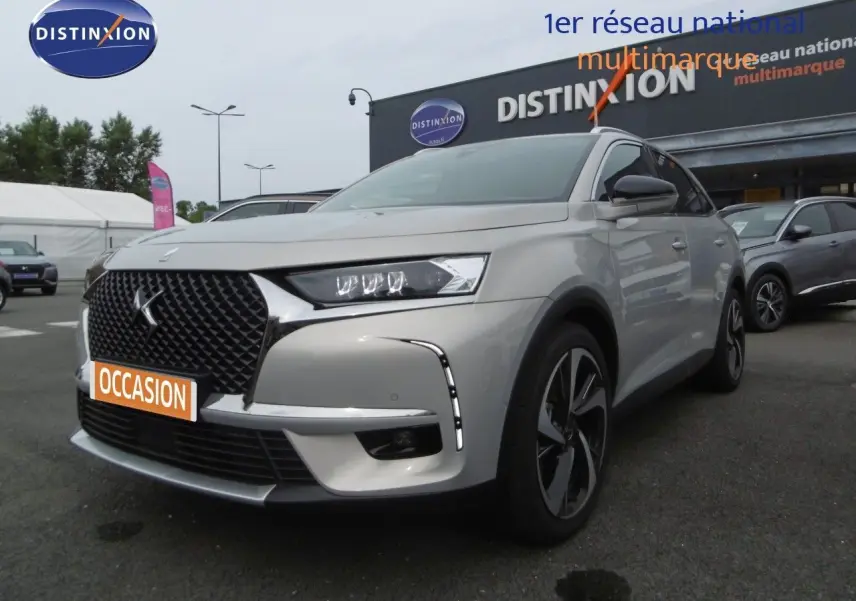 DS7 Crossback hybride rechargeable Crystal Pearl en 3/4 avant droit, avec calandre noire distinctive et jantes stylées.