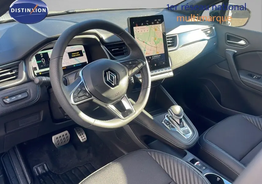 Intérieur du Renault Captur E-Tech hybride 2025, vue côté conducteur, tableau de bord moderne avec écran tactile vertical.